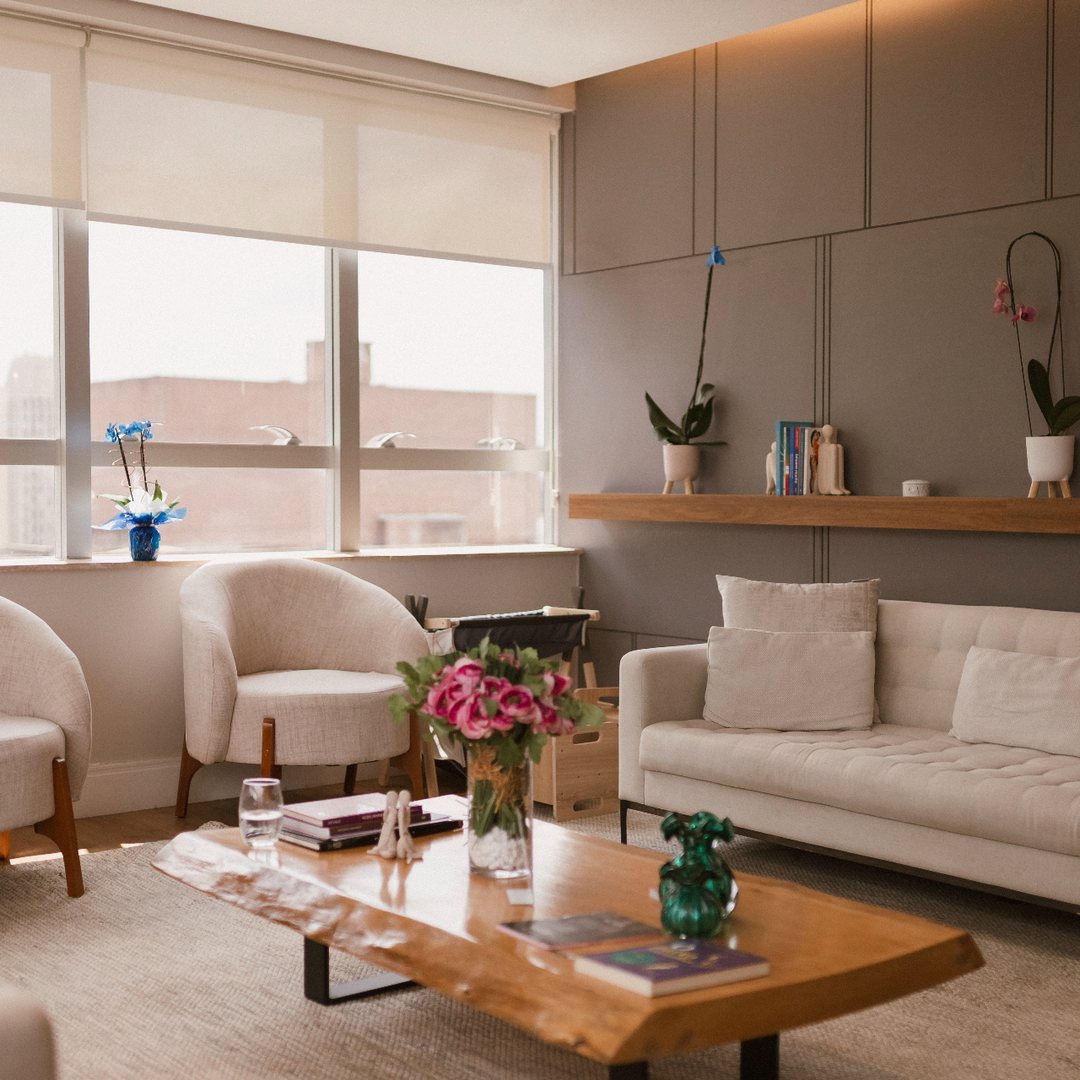 Sala de espera clara, com sofá e poltronas