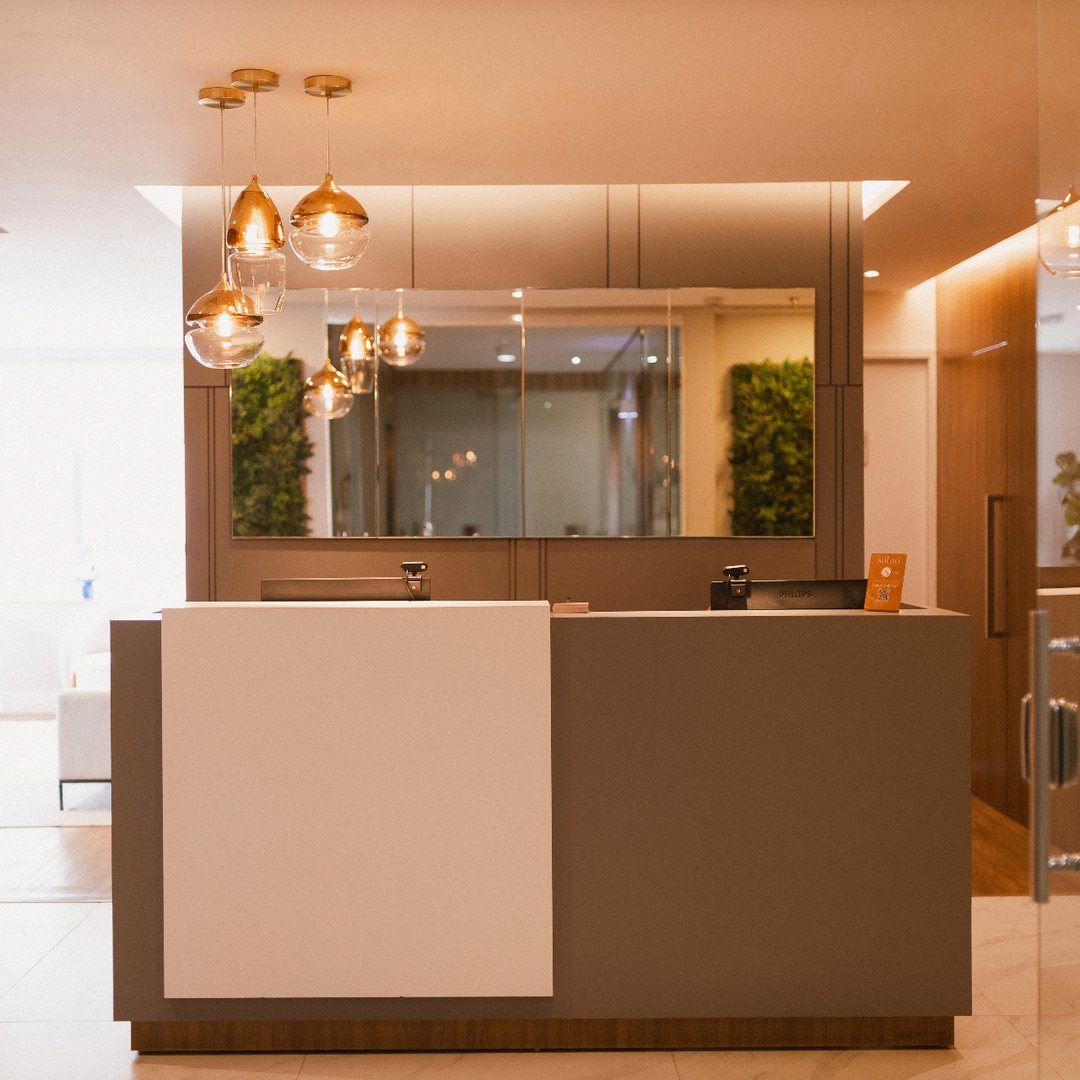 Recepção do consultório com luminárias douradas